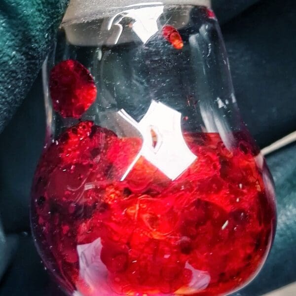 Red curcumin crystals in glass vial