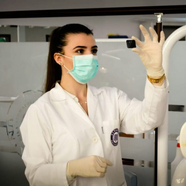 Medical staff in mask holding up sample