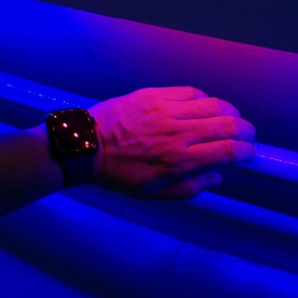 Hand with watch on wrist with blue and pink link