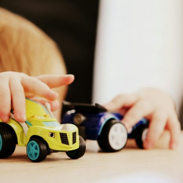 A toddler boy playing with his toy cars